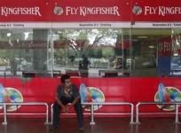 an-airlines-staff-member-sits-in-front-of-a-closed-kingfisher-airlines-ticketing-counter-at-the-airport-in-kolkata-october-3-2012