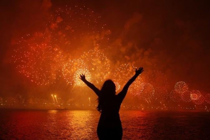 A woman celebrates the New Year as she watches fireworks exploding above Copacabana beach in Rio de Janeiro A woman celebrates the New Year as she watches fireworks exploding above Copacabana beach in Rio de Janeiro