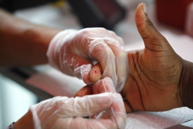 A medical technician draws a blood sample from a patient