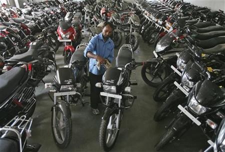 A worker cleans a Hero Splendor motorcycle at a Hero MotoCorp showroom in Jammu October 23, 2012.