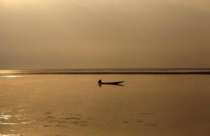 A Kashmiri man catches fish in the waters of Dal Lake on a cold winter morning in Srinagar Snowfall in Kashmir