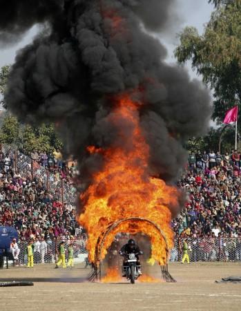 Indian policeman performs a stunt on his motorcycle during the Republic Day parade in Jammu (Reuters)