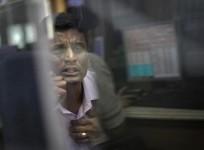 a-broker-looks-at-a-computer-screen-as-he-talks-on-a-phone-at-a-stock-brokerage-firm-in-mumbai-december-3-2012