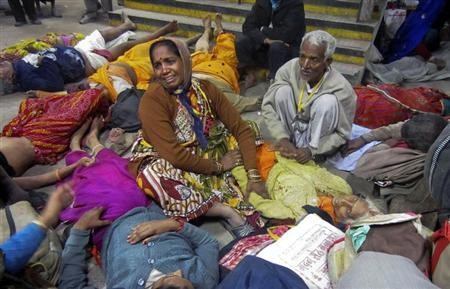 A woman cries as she sits among the bodies of people who were killed when part of a railing from a bridge collapsed at Allahabad railway station February 10, 2013.
