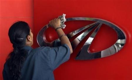 A worker cleans a logo of Mahindra & Mahindra inside their showroom in the southern Indian city of Chennai April 12, 2011. Mahindra & Mahindra