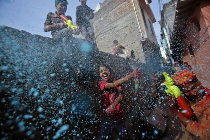Boy sprays coloured foam during Holi celebrations in a lane near the Bankey Bihari temple in Vrindavan Holi 2013