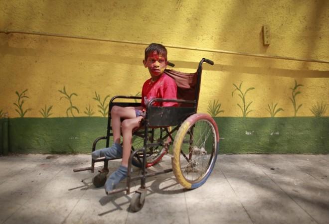 A boy sat in a wheelchair rests after playing during the celebrations of Holi, also known as the festival of colours, at the Society for the Education of the Crippled in Mumbai Holi 2013
