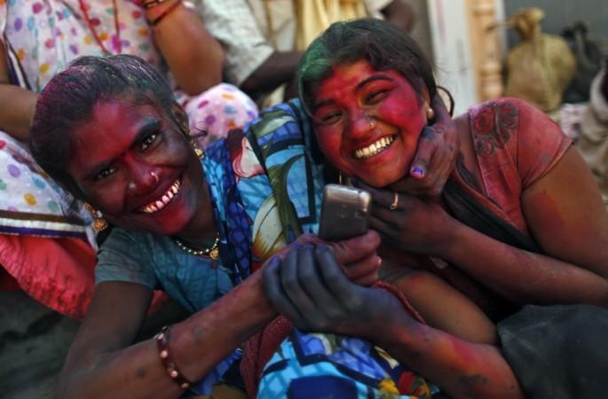Two girls share a moment as they sit outside the Bankey Bihari temple after celebrating Holi in Vrindavan Holi 2013