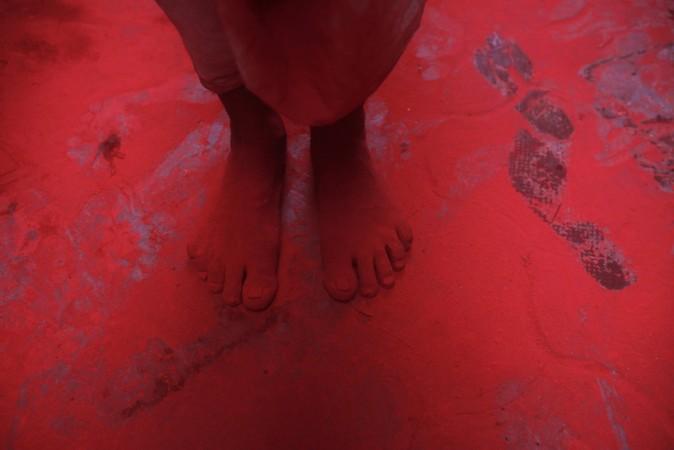 The feet of a man covered in red coloured powder are pictured during Holi celebrations in a lane near the Bankey Bihari temple in Vrindavan Holi 2013