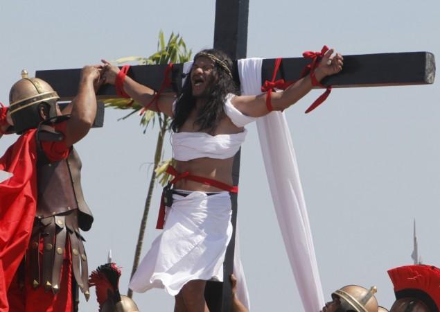 Enaje, who potrays Jesus Christ, screams while a man playing a Roman soldier pulls out a nail from his palm during a Good Friday crucifixion re-enactment in San Pedro Cutud Good Friday