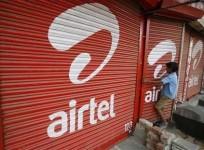 a-boy-closes-the-shutter-of-a-shop-painted-with-an-advertisement-for-bharti-airtel-in-the-western-indian-city-of-ahmedabad