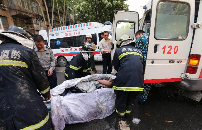 Rescuers move an injured person into an ambulance from the site of a hotel fire in Xiangyang, Hubei province, April 14, 2013. At least 11 people have been confirmed dead and 50 others injured in the fire on Sunday morning,