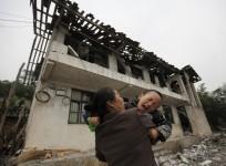 a-boy-cries-as-his-mother-holds-him-in-front-of-their-damaged-house-after-a-strong-6-6-magnitude-earthquake-at-longmen-village-lushan-county-in-yaan-sichuan-province-april-21-2013