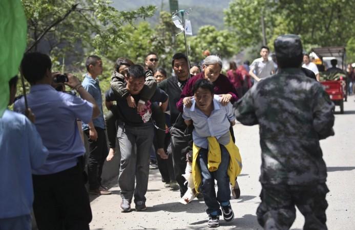 Men carry injured people to an ambulance at Longmen Village, Lushan county, Ya'an, Sichuan province, April 20, 2013.(Reuters) Men carry injured people to an ambulance at Longmen Village, Lushan county, Ya'an, Sichuan province, April 20, 2013.(Reuters)