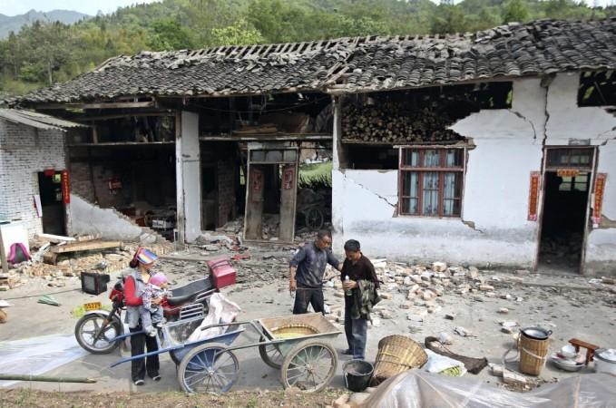 People stand outside a damaged house after a strong 6.6 magnitude earthquake hit, at Longmen village, Lushan county, Ya'an, Sichuan province April 20, 2013. (Reuters) People stand outside a damaged house after a strong 6.6 magnitude earthquake hit, at Longmen village, Lushan county, Ya'an, Sichuan province April 20, 2013. (Reuters)