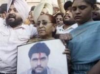 Family members of Sarabjit Singh hold his picture to appeal for his release during a demonstration in Amritsar June 25, 2009.