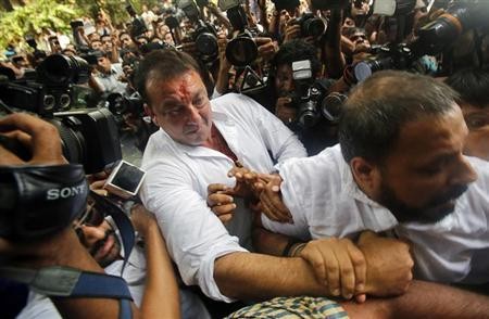 Bollywood actor Sanjay Dutt is escorted by his security staff as he arrives to surrender at a court in Mumbai May 16, 2013.