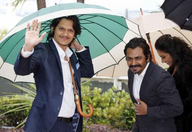 (L-R) Cast members Vijay Varma, Nawazuddin Siddiqui, Tannishtha Chatterjee and director Amit Kumar take cover from rain under umbrellas as they leave after a photocall for the film 'Monsoon Shootout' during the 66th Cannes Film Festival in Cannes May 18, 2013. Cannes 2013