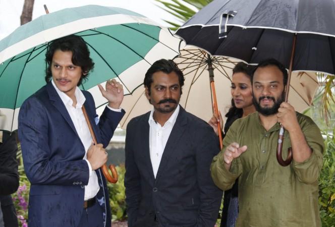(L-R) Cast members Vijay Varma, Nawazuddin Siddiqui, Tannishtha Chatterjee and director Amit Kumar take cover from rain under umbrellas as they leave after a photocall for the film 'Monsoon Shootout' during the 66th Cannes Film Festival in Cannes May 18, 2013. Cannes 2013