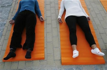 People take part in a free yoga class at the Parque del Oeste in Madrid September 27, 2007.