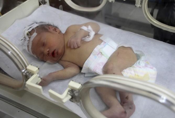 Firefighters and doctors rescue an abandoned newborn baby boy by cutting away a sewage pipe piece by piece, in this still image taken from video, in Jinhua city, Zhejiang province May 25, 2013 (Reuters) Chinese Newborn baby