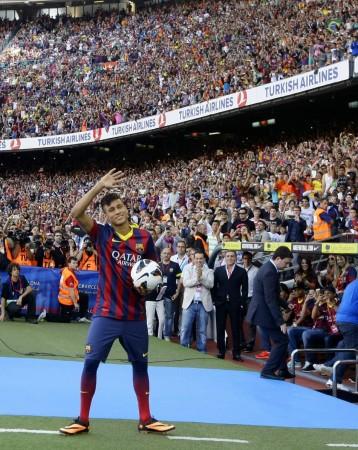 Neymar waves to Barcelona's supporters at his presentation after signing a five-year contract with the club, at Nou Camp stadium in Barcelon Neymar