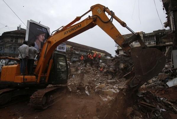 An excavator is used to move debris as rescue workers search through rubble at the site of a collapsed residential building in Mumbai. (Reuters) Mumbai building collapse