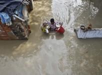 a-resident-carries-his-belongings-through-an-alley-flooded-with-the-rising-water-level-of-river-yamuna-after-heavy-monsoon-rains-in-new-delhi-reuters