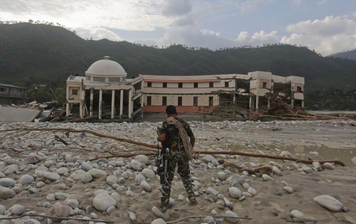 A member of the rescue operation team of Sashastra Seema Bal (SSB) or Armed Border Force walks towards the officers training centre damaged by floods at their campus in Srinagar in the Himalayan state of Uttarakhand. (Reuters) North India