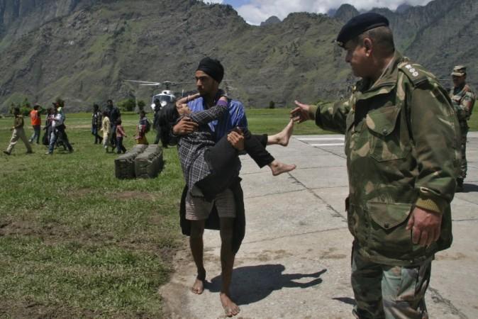 A man carries a flood affected victim after they were rescued by the Indian army after heavy rains in the Himalayan state of Uttarakhand June 19, 2013. (Reuters) North India Floods