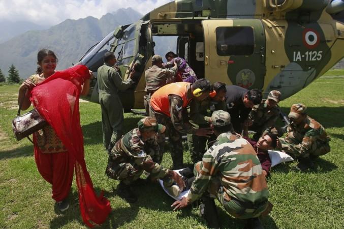 A woman cries as her husband is put on a stretcher by soldiers from an army helicopter, during a rescue operation at Joshimath in the Himalayan state of Uttarakhand June 21, 2013. (Reuters) North India Floods
