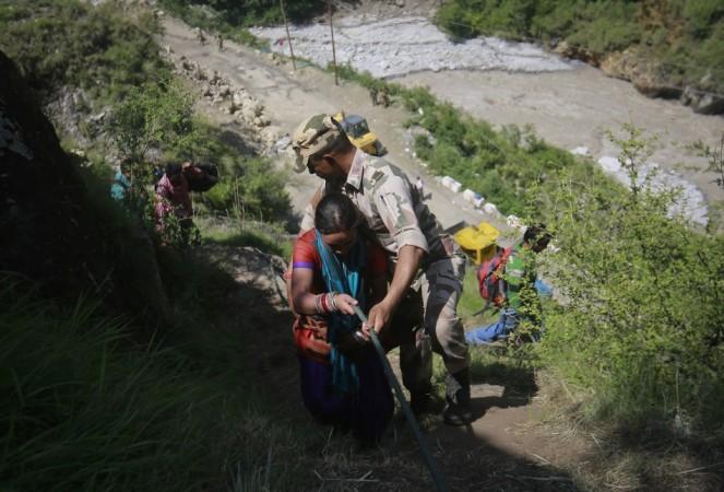 A woman is helped by soldiers to climb down a hill during a rescue operation at Govindghat in the Himalayan state of Uttarakhand June 21, 2013. (Reuters) North India Floods
