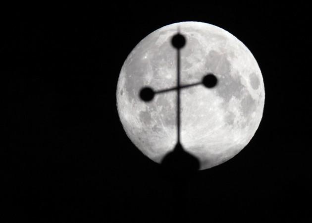 The super moon is pictured behind the cross of a church in Vienna June 23, 2013. (Reuters) Supermoon
