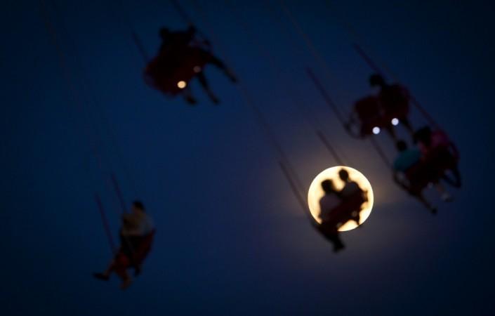 People ride the Luna Park Swing Ride as the Super Moon rises on Coney Island, June 22, 2013. (Reuters) Supermoon 2013