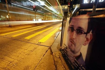 A bus passes by a poster of Edward Snowden, a former contractor at the National Security Agency (NSA), displayed by his supporters at Hong Kong's financial Central district.