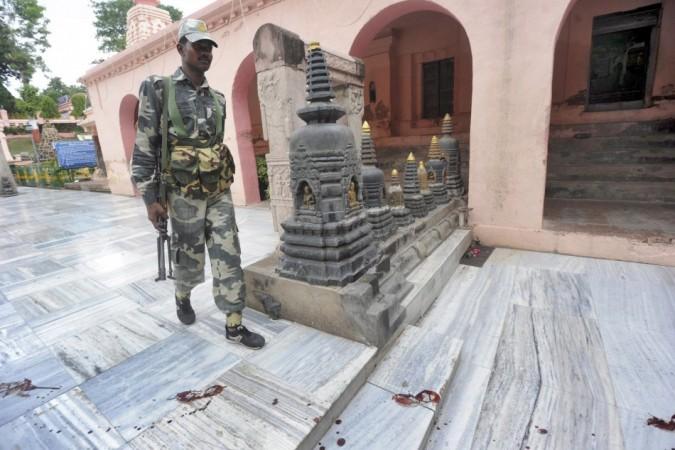 A security personnel walks among bloody footprints inside the Mahabodhi temple complex, after a series of explosions at Bodh Gaya in the eastern Indian state of Bihar July 7, 2013. Mahabodhi temple complex