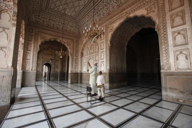 A worker cleans a chandelier inside the Badshahi Mosque ahead of the holy month of Ramadan in Lahore, July 9, 2013. REUTERS/Mohsin Raza Ramadan
