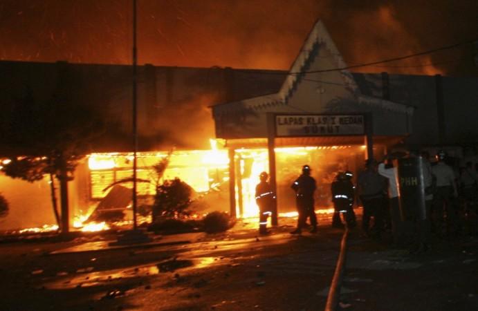 Fire-fighters and police officers stand outside Tanjung Gusta prison, which was set ablaze by inmates after a riot broke out, in Medan in North Sumatra province(Reuters)
