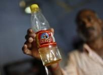 a-policeman-in-civilian-clothes-shows-a-bottle-containing-oil-which-they-recovered-from-the-school-where-contaminated-meals-were-served-to-children-on-16-july-at-a-police-station-in-masrakh-at-chapra-district-of-the-eastern-indian-state-of-bihar