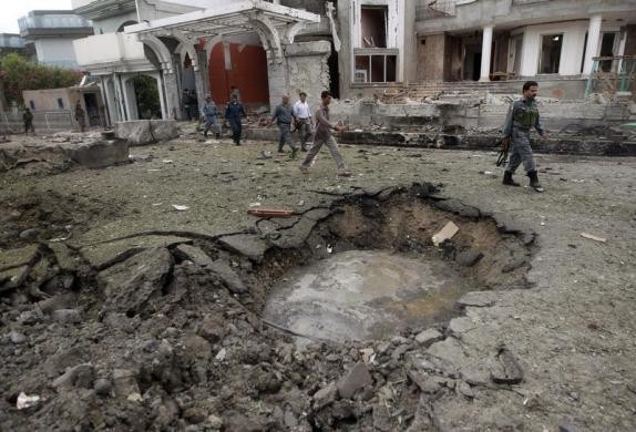 Afghan policemen walk near a crater at the site of a suicide attack at the Indian consulate in Jalalabad province August 3 2013