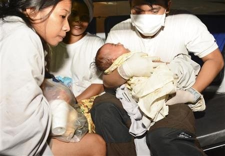 A rescuer carries an infant child survivor  of the passenger vessel MV St Thomas Aquinas that sank after colliding with a cargo ship, to a hospital in Talisay, Cebu in Central Philippines August 17, 2013-REUTERS/STRINGER
