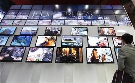 A visitor takes photos of TV sets made with LG Display flat screens at an exhibition in Goyang, north of Seoul, October 15, 2009.
