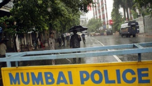 Security stand guard on a road in Mumbai.