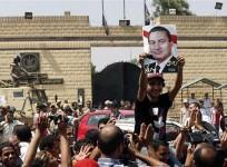 a-supporter-holds-a-poster-of-hosni-mubarak-outside-tora-prison