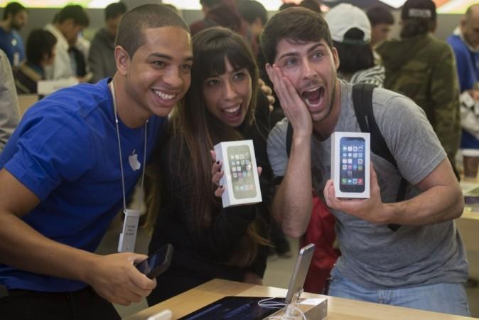 Customers and Apple employee pose with new Apple iPhone 5s phones at the Apple Retail Store in Manhattan, New York iPhone 5s