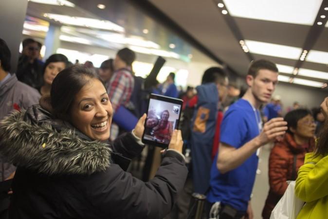 Shirly Tishler of Israel uses an iPad mini to speak to her family back home as she awaits in line to purchase the new Apple iPhone 5S phone in Manhattan iPhone 5S