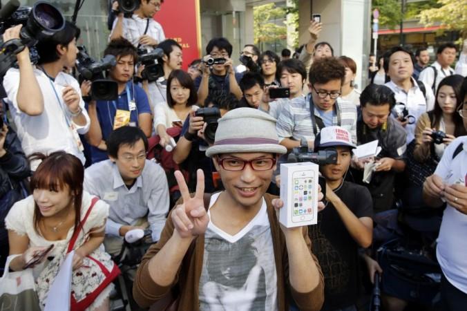 A man poses with a box of the new Apple iPhone 5S for the media after he waited for it since September 10 outside an Apple Store at Tokyo's Ginza shopping district iPhone 5S