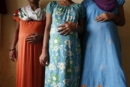 Surrogate mothers (L-R) Daksha, 37, Renuka, 23, and Rajia, 39, pose for a photograph inside a temporary home for surrogates provided by Akanksha IVF centre in Anand town, about 70 km (44 miles) south of the western Indian city of Ahmedabad August 27, 2013