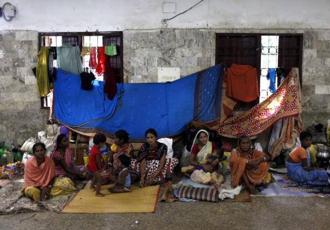 People take shelter at a wedding hall after leaving their houses to take shelter from the impact of the approaching Cyclone Phailin, in the eastern Indian state of Odisha Cyclone Phailin