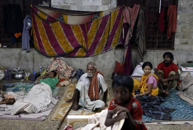 People take shelter at a wedding hall after leaving their houses to take shelter from the impact of the approaching Cyclone Phailin, in the eastern Indian state of Odisha Cyclone Phailin